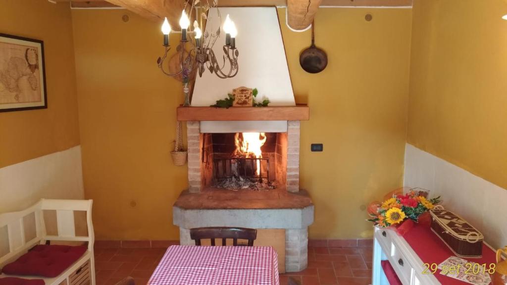 ein Wohnzimmer mit einem Kamin und einem Tisch in der Unterkunft Casa Cesira in Tarzo