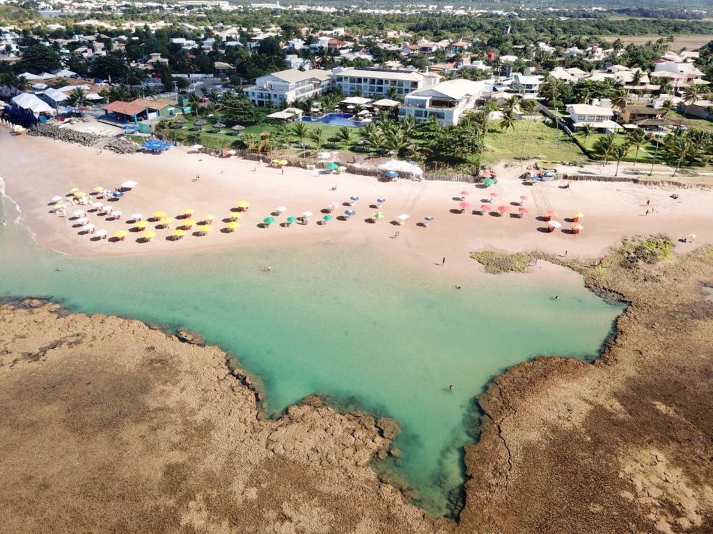 an aerial view of a beach with chairs and umbrellas at Paraiso dos Corais in Guarajuba