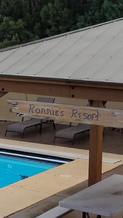 a sign that reads roms resort sitting next to a swimming pool at Ronnie's Resort in Payson