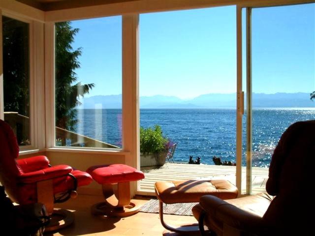 a living room with a view of the ocean at Orca View Cottage in Sooke