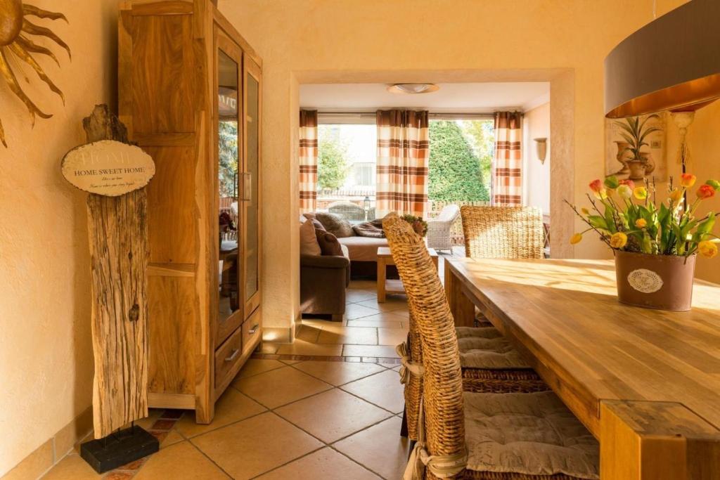 Un comedor con mesa y sillas de madera. en Altes Strandhus Casa Seestern, en Scharbeutz
