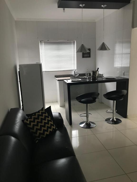 a kitchen with a couch and a table with chairs at Green House Apartamentos in Ubá