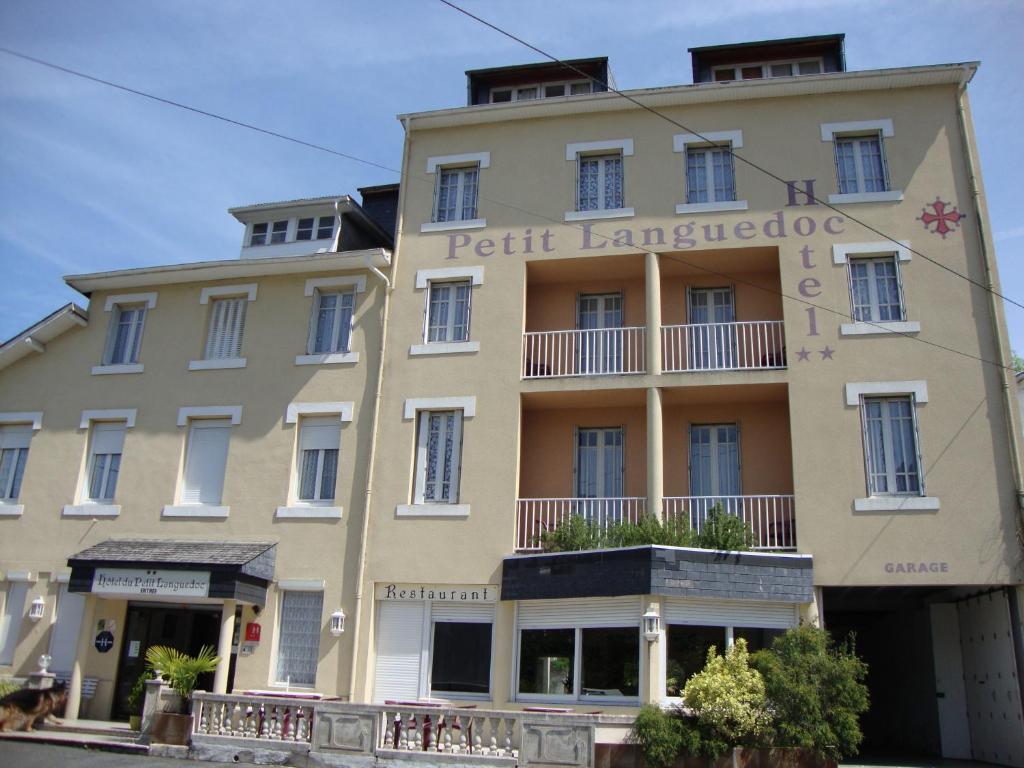 un edificio con un cartel en la parte delantera en Hôtel Au Petit Languedoc, en Lourdes