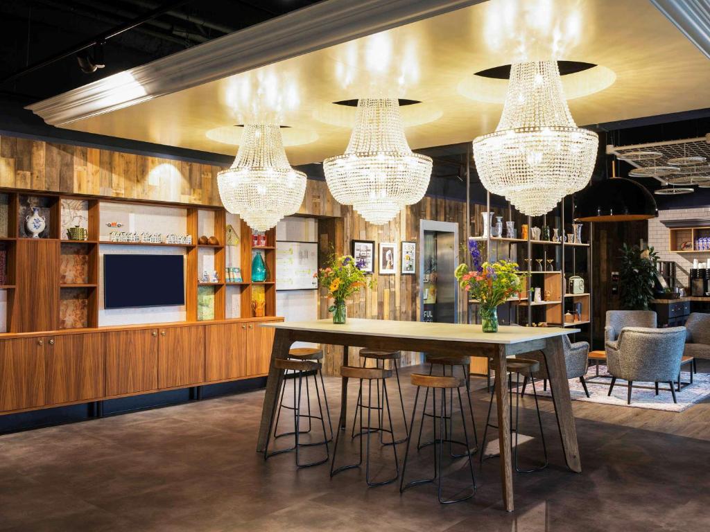 a dining room with a table and chairs and chandeliers at ibis Amsterdam Centre in Amsterdam