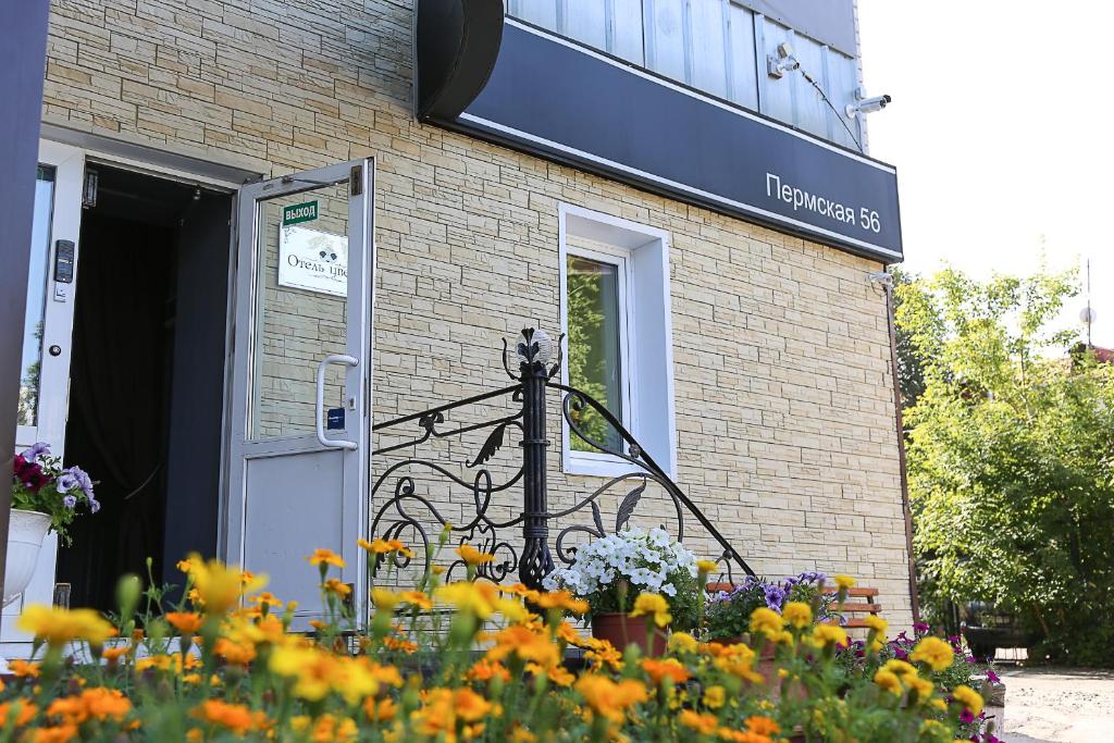 una señal en el lateral de un edificio de ladrillo con flores en Hotel "Otel flowerS", en Perm