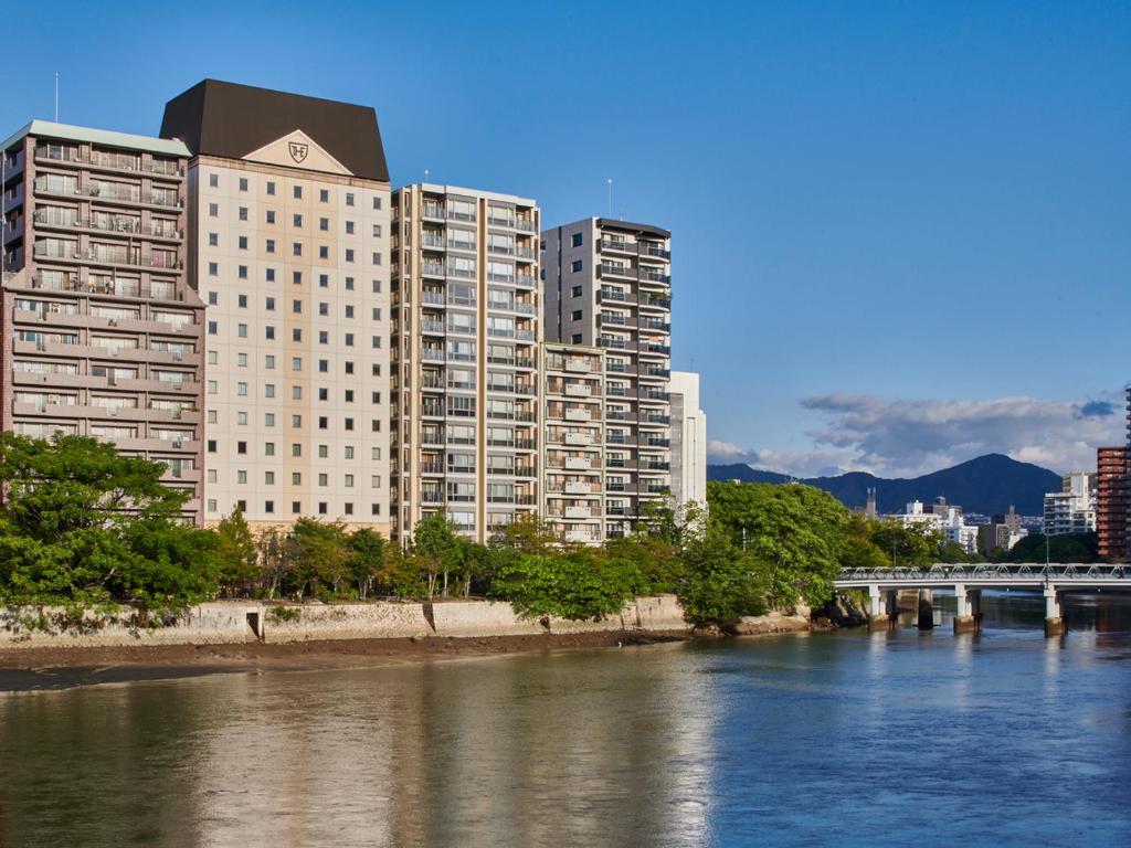 Blick auf einen Fluss mit Gebäuden und einer Brücke in der Unterkunft The Royal Park Hotel Hiroshima Riverside in Hiroshima