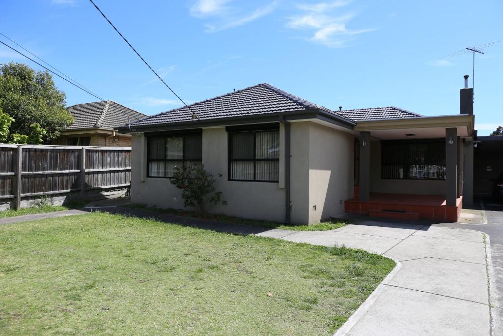 a white house with a fence and a yard at Isle of Serenity Charming House in Keysborough