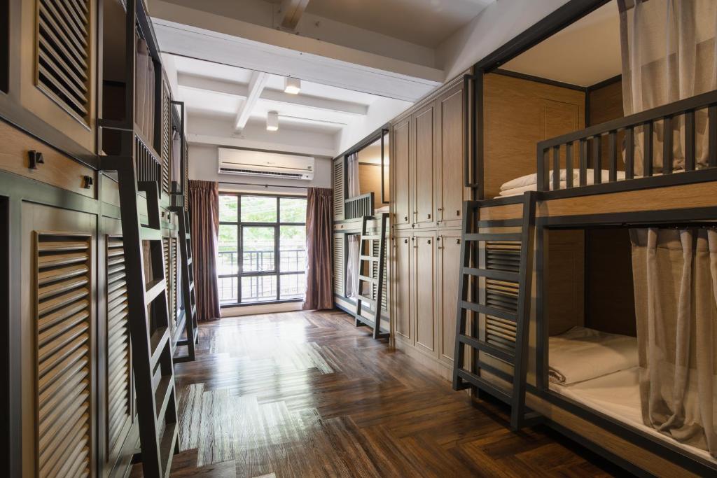 a room with bunk beds and a hallway at Warm Window Silom in Bangkok