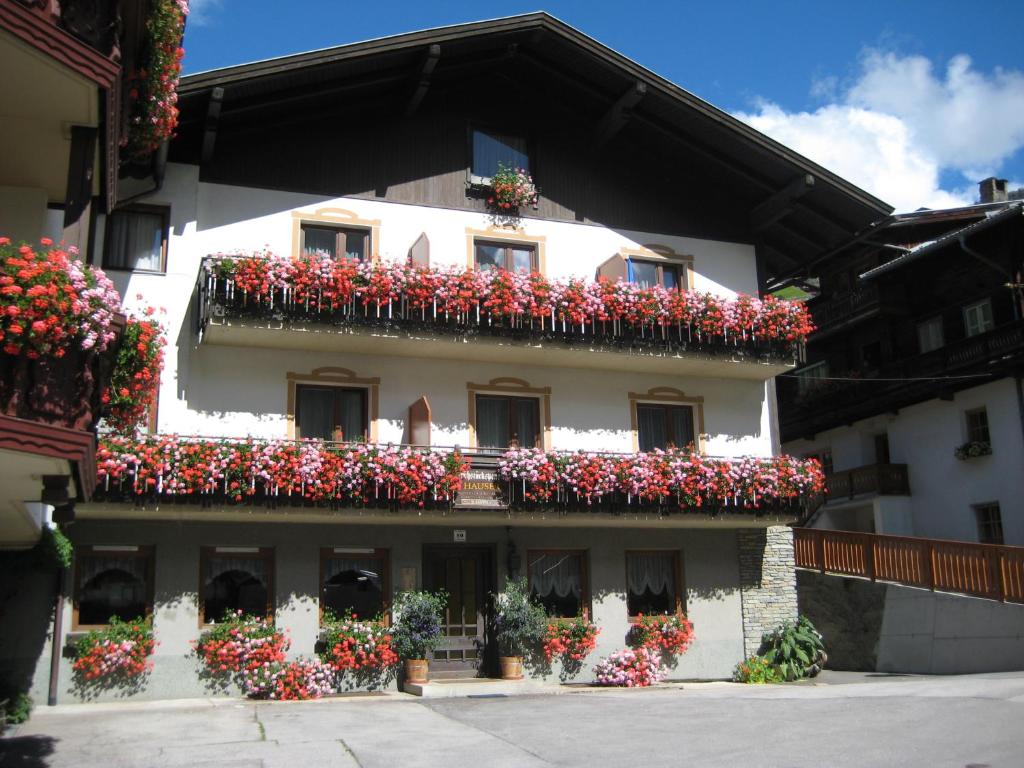 un bâtiment avec des fleurs sur son côté dans l'établissement Ferienwohnungen Hauser, à Sankt Jakob in Defereggen