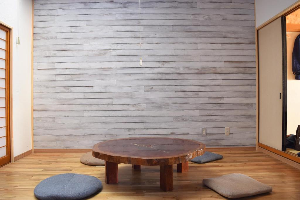 a wooden table in a room with a wooden wall at Guest House Minato in Miyako