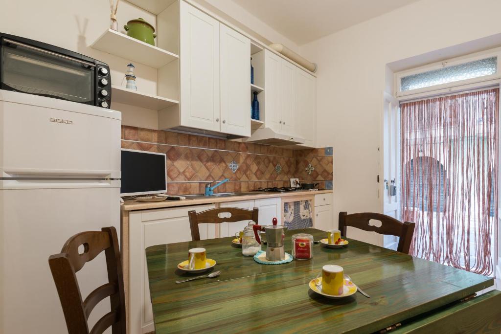 a kitchen with a wooden table and a refrigerator at Brezza di Mare - Sea Breeze in Villanova di Ostuni