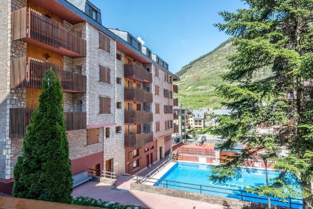 a view of a building with a swimming pool at Homenfun Baqueira-Beret Vielha in Vielha