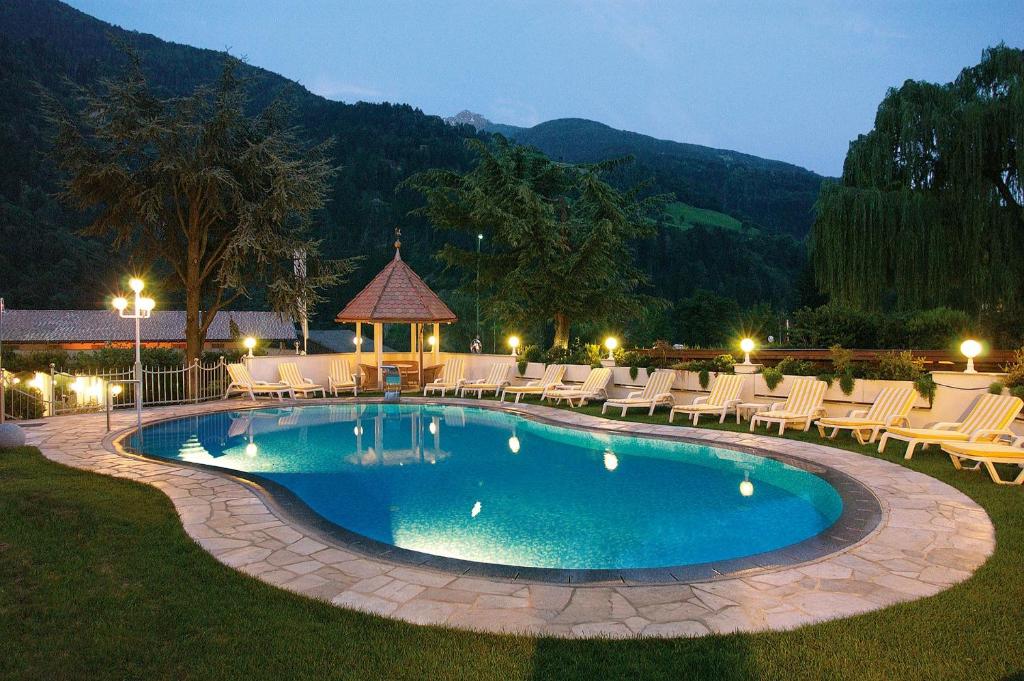 una piscina con tumbonas y un cenador en Hotel Hirzer ***S, en Saltusio