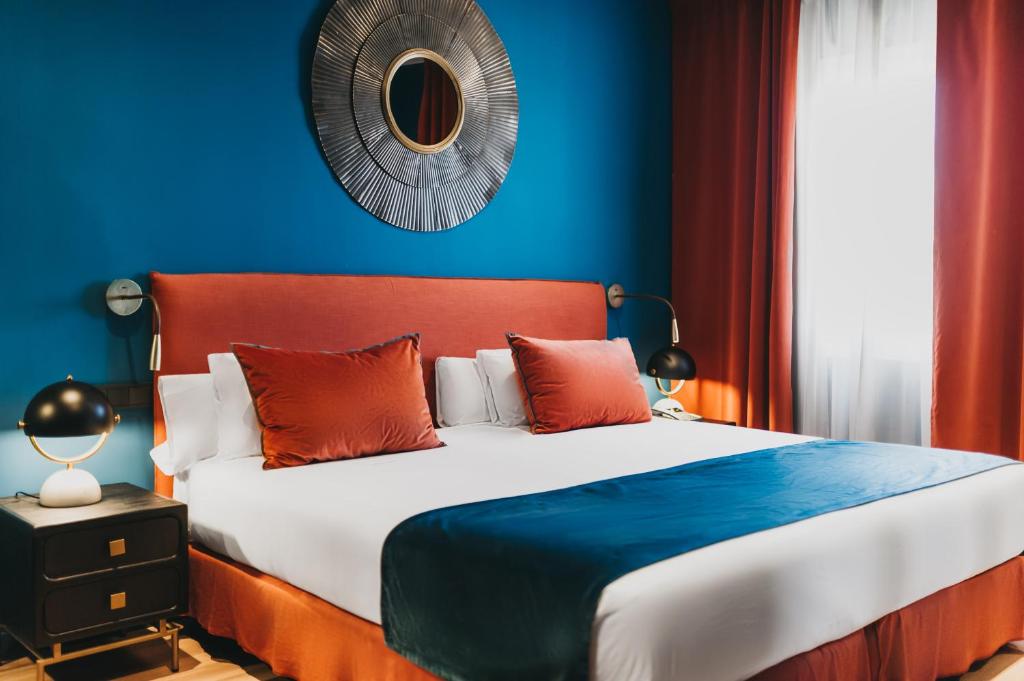 a bedroom with a large bed with a blue wall at Arenas Atiram Hotel in Barcelona