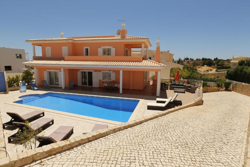una villa con piscina frente a una casa en Casa Antonio, en Armação de Pêra
