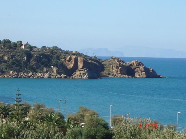 une grande étendue d'eau avec une île rocheuse dans l'établissement Holidays Cefalù, à Cefalù
