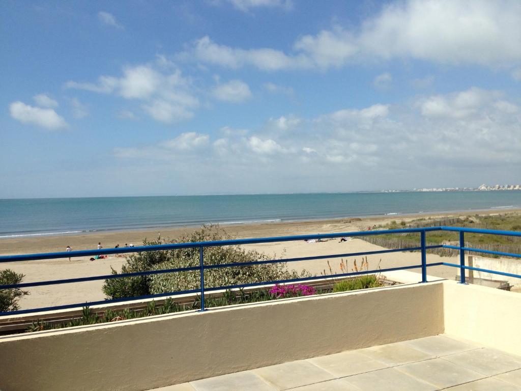 uma vista para a praia a partir da varanda de um condomínio em Exceptionnel, sur la plage en front de mer em Le Grau-du-Roi