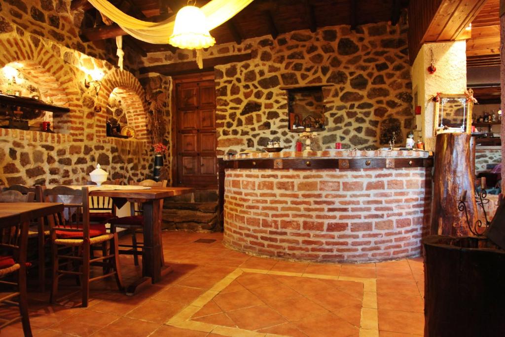 um restaurante com mesas e uma parede de tijolos em Iaspis Guesthouse em Sidhirokhórion
