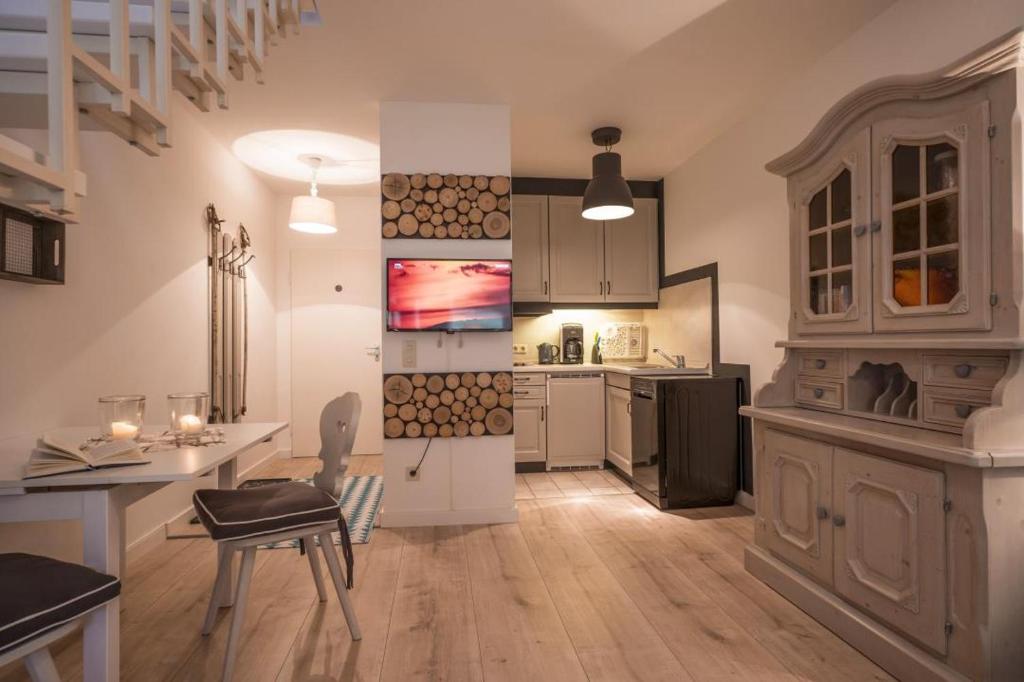 a kitchen with a dining table and a kitchen with a stove at Bergschlössl - Massionettwohnung 13 in Oberaudorf