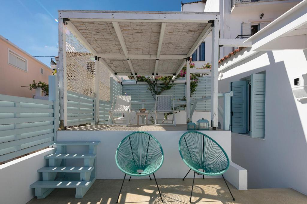 a balcony with two chairs and awning at moonhouse in Skiathos