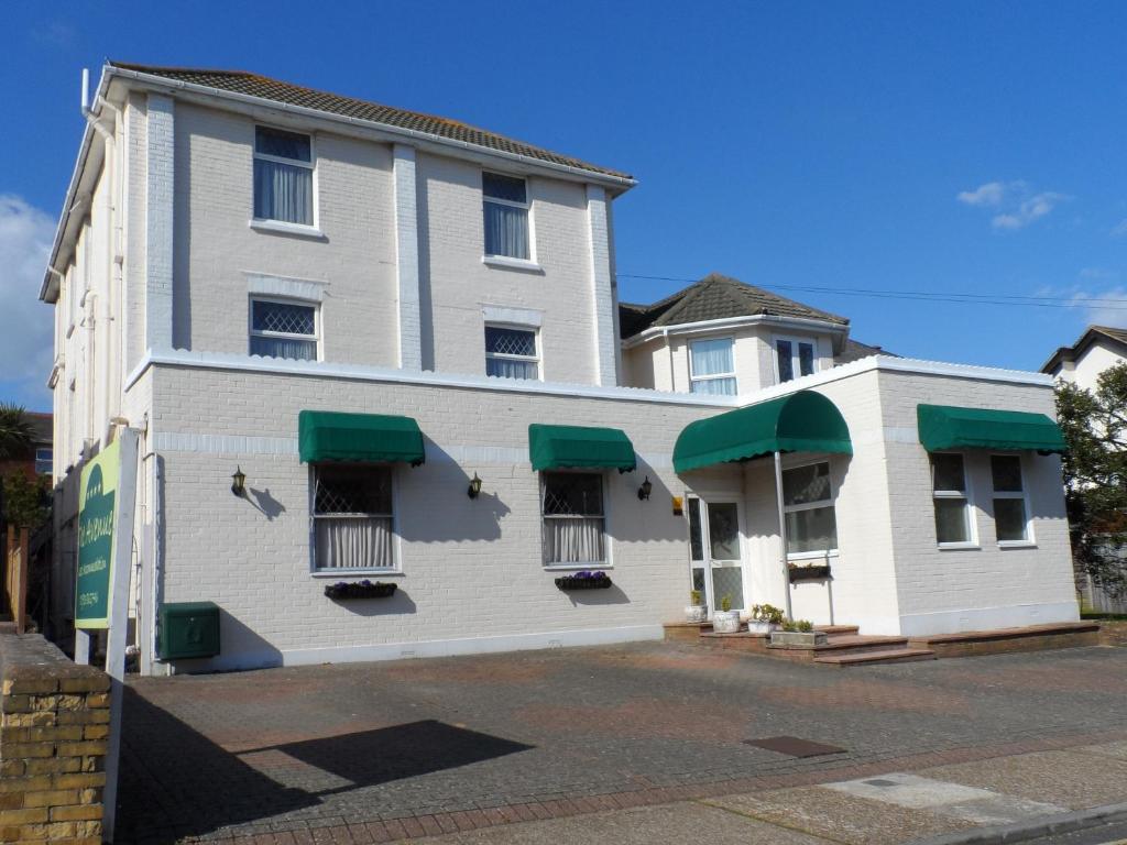 a white building with green awnings on it at The Avenue in Shanklin
