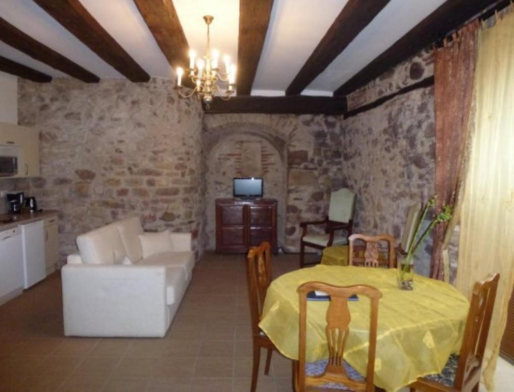 a living room with a table and a couch at Les Remparts de Bergheim in Bergheim