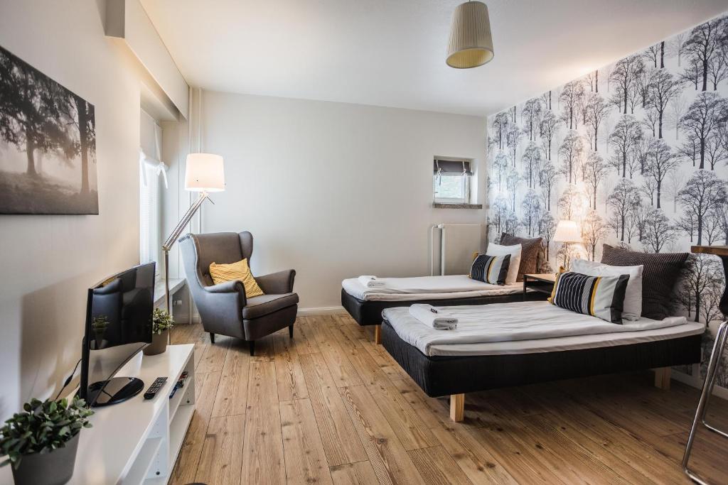 ein Wohnzimmer mit einem Sofa und einem Stuhl in der Unterkunft Haave Apartments in Valkeakoski