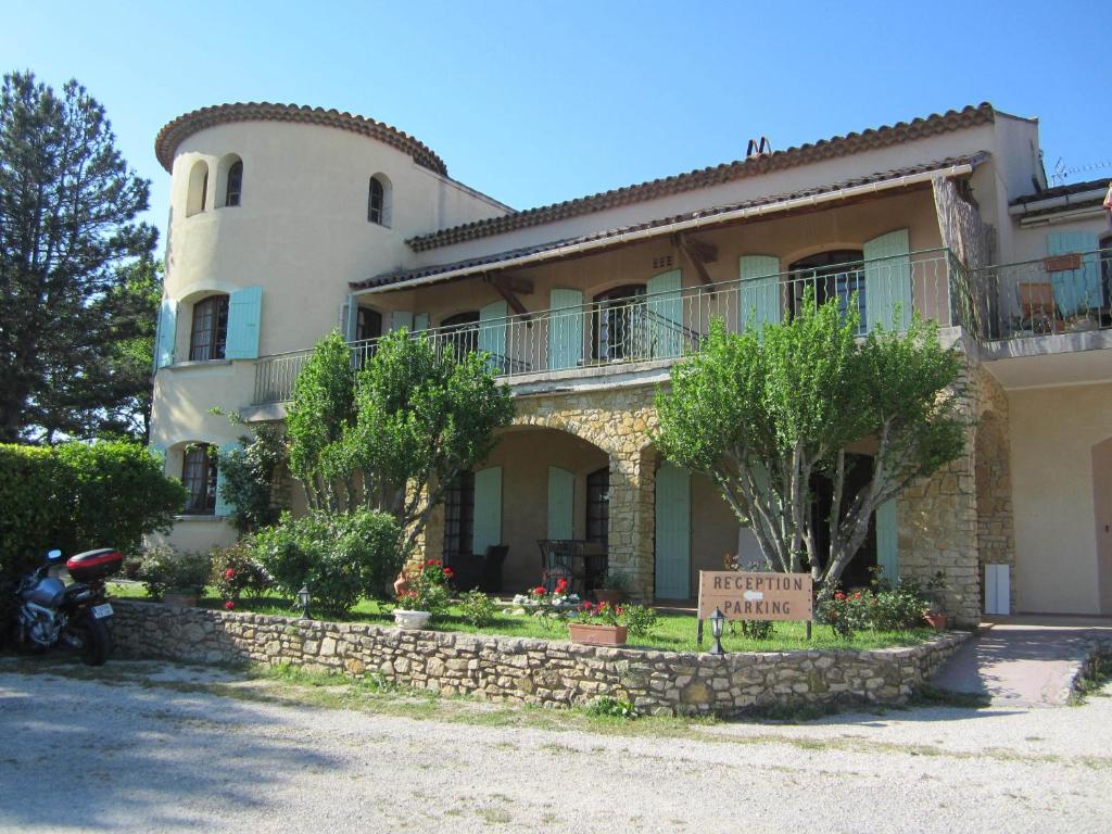 a house with a motorcycle parked in front of it at Logis du Comte in Suze-la-Rousse