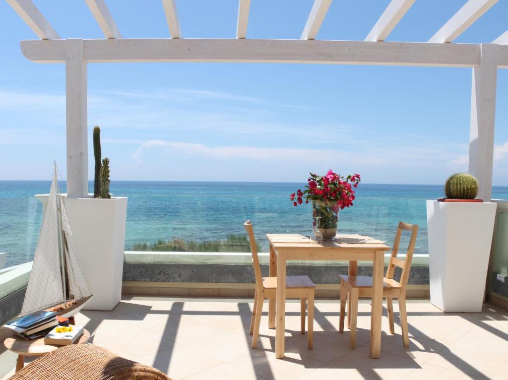 una mesa y sillas con vistas al océano en Residence Solar, en Torre Ovo