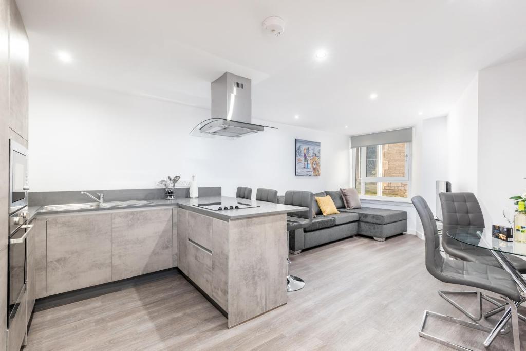 a kitchen and a living room with a couch at Casa Fresa - Castlehill Apartment in Dundee