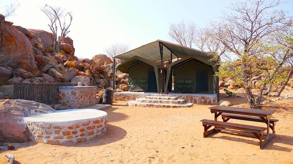 un edificio con mesa de picnic y banco en Madisa Camp, en Kalkbron