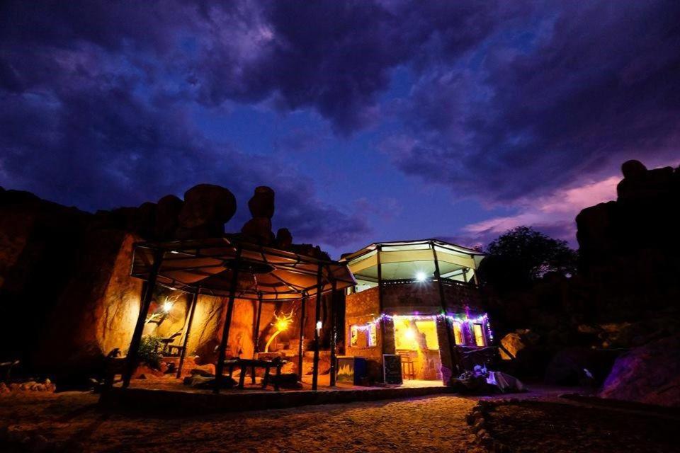 un edificio con una cúpula de cristal por la noche en Madisa Camp, en Kalkbron