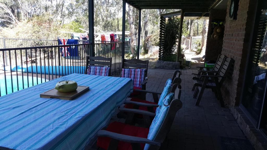 un tavolo blu e sedie su un patio di Gowrie Agapanthus a Singleton