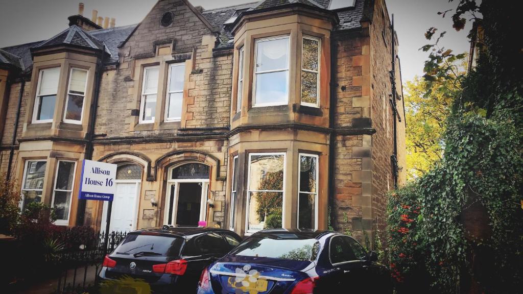 dois carros estacionados em frente a uma casa de tijolos em Allison House 16 em Edinburgo