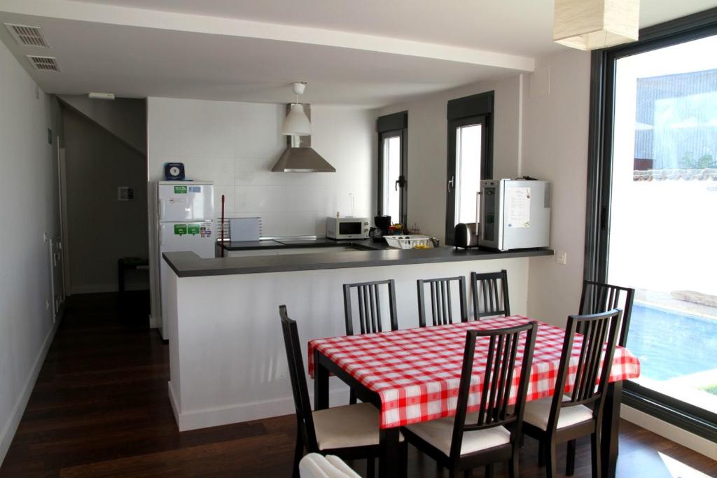 cocina con mesa y sillas rojas y blancas en Casa Oretani en Picón