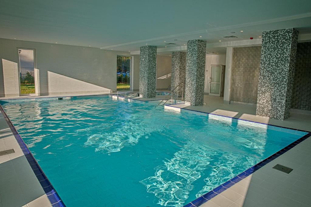 una grande piscina con acqua blu in un edificio di Mielno Holiday Apartments a Mielno