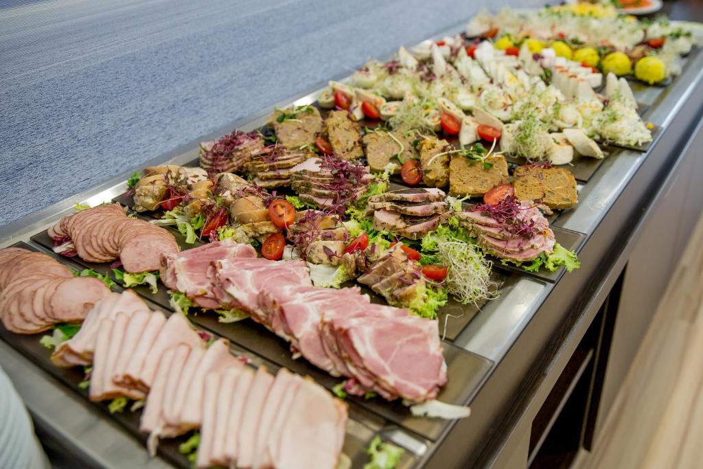 Assorted cold cuts and appetizers arranged on platters for hotel buffet service.