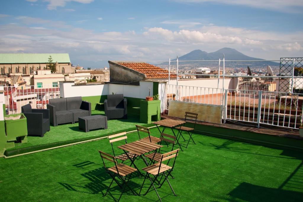 eine Terrasse mit Stühlen und Tischen auf dem Dach in der Unterkunft C era Una Volta in Neapel