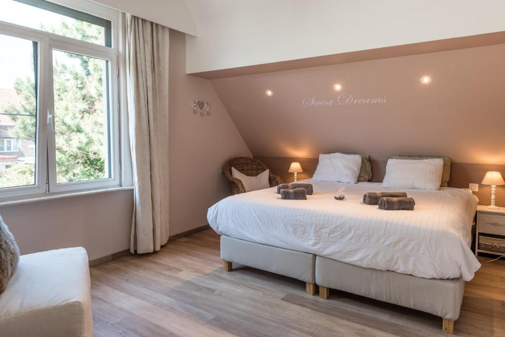 a bedroom with a large bed and a window at B&B Alegría in Mechelen