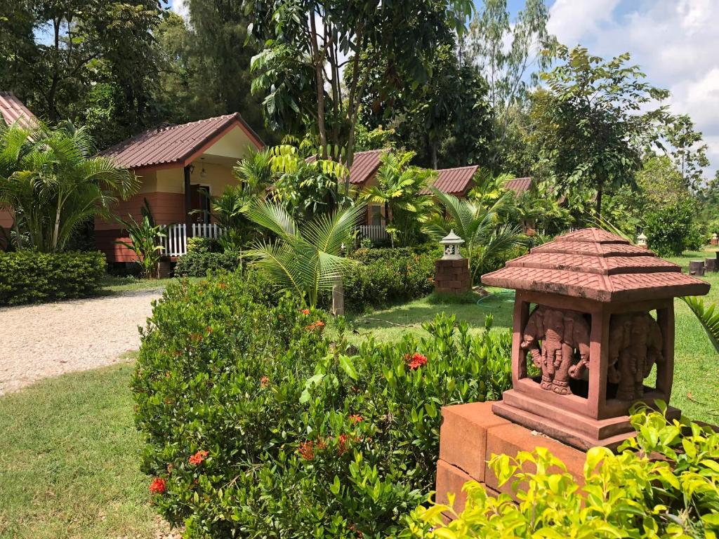 un jardín con una pequeña estatua en el césped en Sukhothai Indy Resort, en Sukhothai