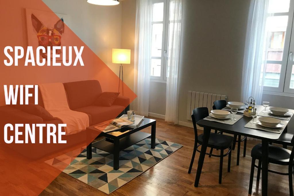 - un salon avec un canapé et une table avec des chaises dans l'établissement Premium Appart Albi, à Albi