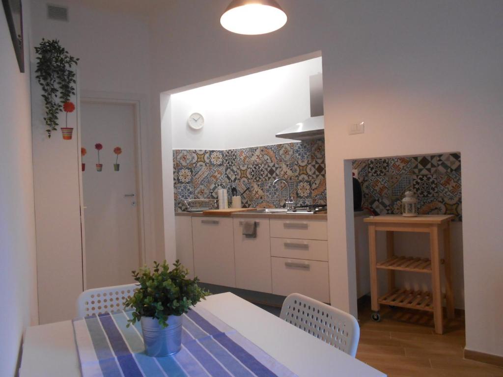 una cucina con tavolo e sedie e una cucina con bancone di CIVICO 47 a Pisa