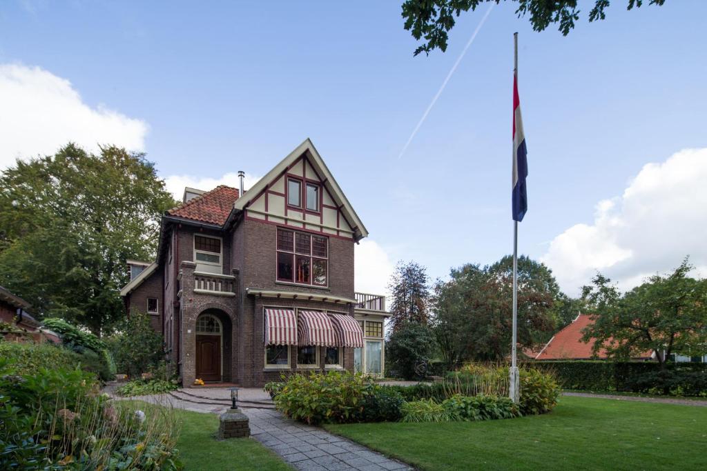 ein Haus mit einer Flagge im Hof in der Unterkunft Burgers & Buitenlui in Diever