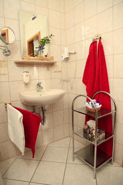 a bathroom with a sink and a red towel at Hotel Zur Fernmühle in Ziegenrück