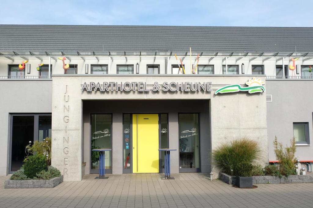 a building with a yellow door in front of it at Jungingers Aparthotel in Holzheim