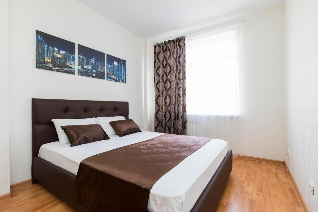 a bedroom with a large bed and a window at Апартаменты на Тимирязева 35 in Nizhny Novgorod