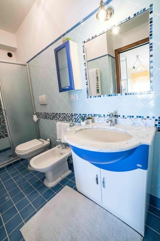 a bathroom with a sink and a toilet and a mirror at Villa Sofia in Taormina