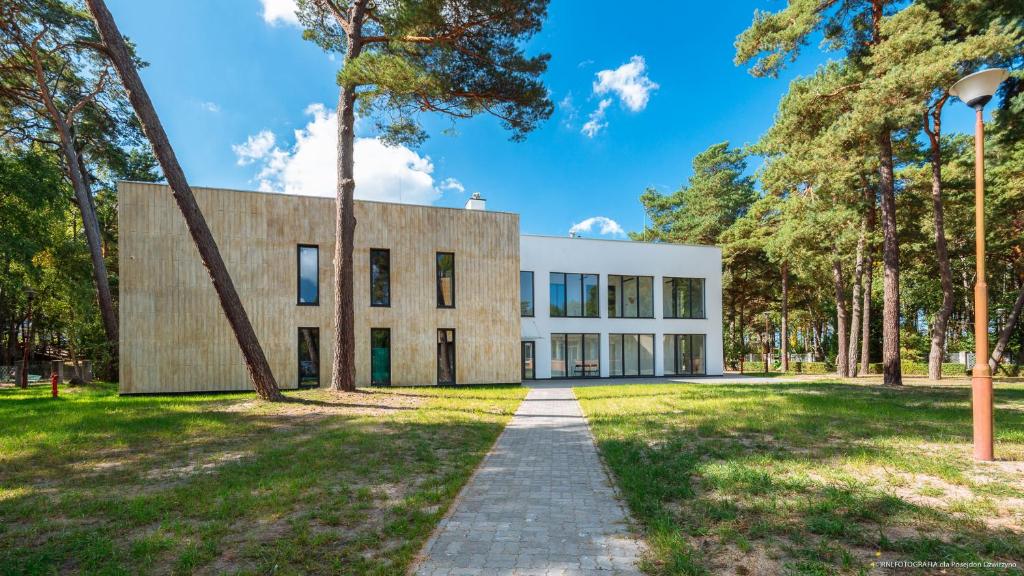 an office building in a park with trees at OW Posejdon Dźwirzyno in Dźwirzyno