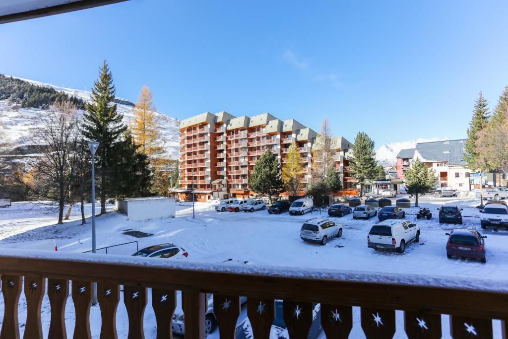 un parking avec des voitures garées dans la neige dans l'établissement Vacancéole - Résidence Plein Sud, à Les Deux Alpes