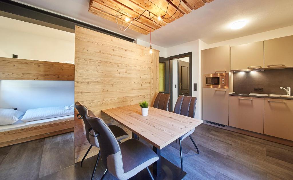 a kitchen and dining room with a wooden table and chairs at Time for Sport Apartments in Saalbach-Hinterglemm